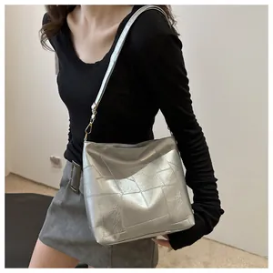 Silberne Umhängetasche mit Metallic-Finish und Patchwork-Nähten am Modell gezeigt