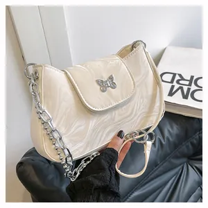 Close-up of stylish off-white marble texture shoulder bag with silver butterfly buckle