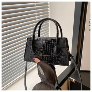Detailopname van zwarte krokodillenleer textuur met gouden Fashion & Bags belettering