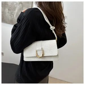 Détail du sac à bandoulière blanc motif crocodile avec boucle dorée élégante en forme de U