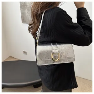 Détail du sac bandoulière argenté à motif crocodile avec boucle en métal doré
