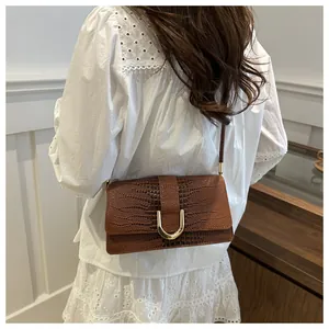 Détail du sac bandoulière marron motif crocodile avec boucle en métal doré en fer à cheval