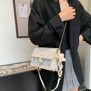 Elegant plaid tweed crossbody bag with gold chain strap and silk scarf accessory