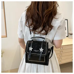Detailaufnahme des schwarzen Lederrucksacks mit Sternen-Nieten und modischem Logo-Druck