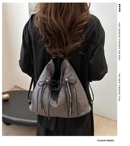 Rückansicht eines grauen Polka-Dot-Rucksacks mit vertikalen Reißverschlüssen auf Stoff
