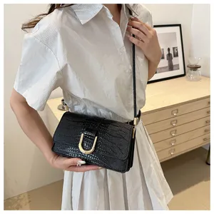 Détail du sac à bandoulière noir motif crocodile avec boucle métallique en U dorée