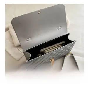 Intérieur du sac matelassé argenté montrant l'espace pour téléphone et portefeuille