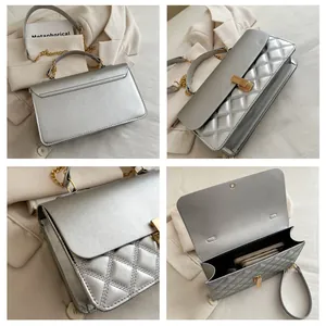 Détails de la couture en losange argentée, du fermoir doré et de la texture en cuir PU