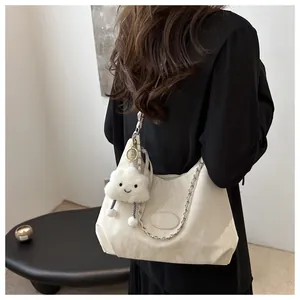 Detail of a pleated off-white shoulder bag with silver chain and plush cloud charm