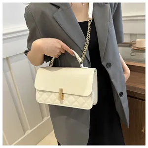 Détail du sac matelassé beige avec fermoir doré et bandoulière en chaîne chic