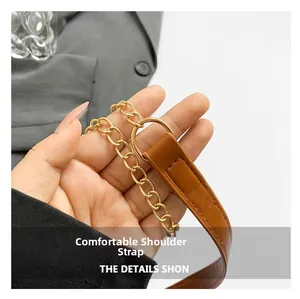 Detail of comfortable brown leather shoulder strap with gold metal chain on small square bag