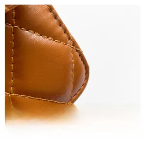 Close-up of brown quilted leather texture with precise stitching on a crossbody bag