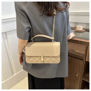 Détail du sac à bandoulière matelassé beige avec chaîne dorée et fermoir métallique