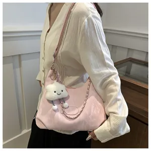 Detail of pink pleated hobo bag with silver chain and cute cloud plush charm accessory