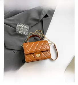 Close-up of caramel brown quilted shoulder bag with golden twist lock and metal chain