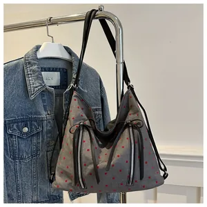 Detail der grauen Polka-Dot-Tasche mit Silberreißverschlüssen und Lederquasten