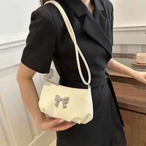 Elegant cream shoulder bag with silver 3D butterfly buckle and pleated texture
