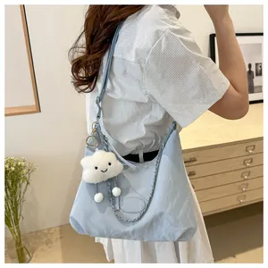Detail of light blue pleated shoulder bag with cute plush cloud pendant and metal chain