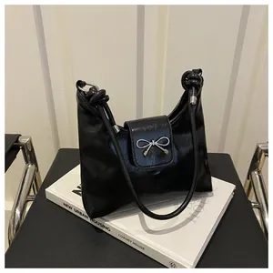Sac hobo noir en cuir brillant avec noeud métallique argenté et bandoulière nouée