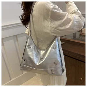 Silver crescent shoulder bag featuring 3D butterfly metal ornaments in a Y2K fashion style