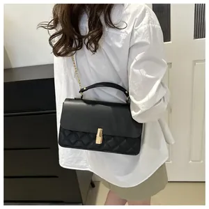 Vue arrière d'un mannequin portant un sac à bandoulière noir matelassé avec chaîne dorée