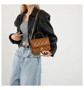 Close-up of quilted brown leather crossbody bag with gold-tone twist lock and chain strap
