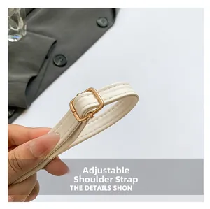 Dettaglio della tracolla regolabile in pelle beige con fibbia in metallo dorato