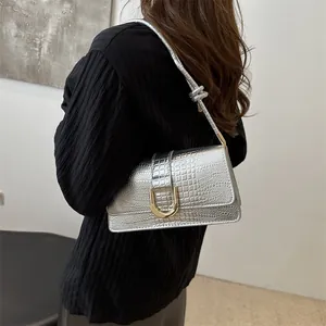 Sac à bandoulière argenté avec gaufrage crocodile et boucle dorée en forme de U