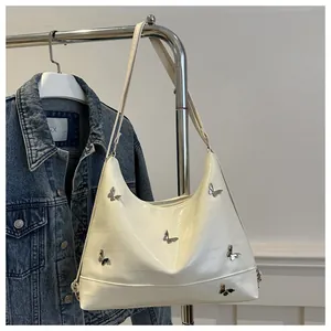 Detail of white glossy hobo bag with silver butterfly hardware and adjustable strap