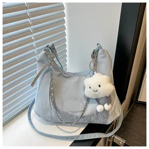 Detail of light blue crescent bag featuring pleated nylon texture and plush cloud charm