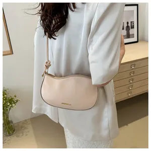 Fashionable beige crescent hobo bag with unique knot shoulder strap and logo detail