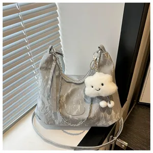 Close-up of silver pleated tote bag with glossy metallic texture and cloud plush charm