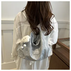 Silver metallic pleated tote bag shown on a model featuring a cute white cloud pendant