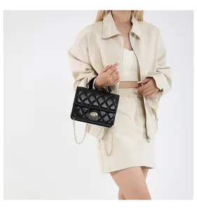 Detailed close-up of the vintage quilted pattern and gold metal twist-lock on the black bag