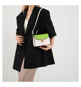 Dettaglio di una piccola borsa quadrata bicolore con patta verde e chiusura in metallo