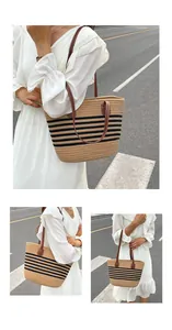 Detailansicht der gestreiften Strohtasche mit braunen Ledergriffen und Nieten