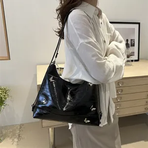 Fashionable black glossy underarm bag with silver butterfly hardware for women