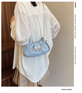 Détail du sac nuage plissé bleu clair avec boucle papillon argentée et perles