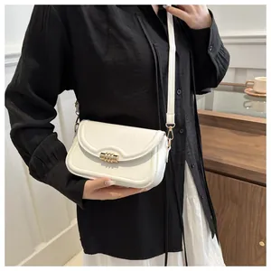 White leather crossbody bag with gold metallic swivel lock shown on shoulder for daily style