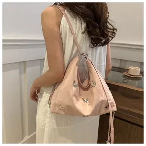 Close-up of pink butterfly tote with metallic ornaments and pleated texture on model