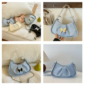 Détail du sac nuage plissé avec anse en perles et boucle papillon métallique élégante