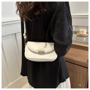 Detailed back view of white leather crossbody bag with gold buckle and wavy flap design