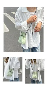 Detail of light green drawstring bucket bag showing compact size and nylon texture