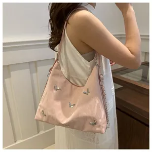 Detail of pink butterfly tote bag with glossy wrinkled texture and silver chain