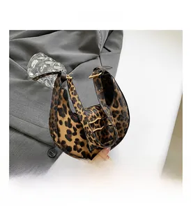 Close-up of leopard print shoulder bag with golden hardware and luxury fabric texture