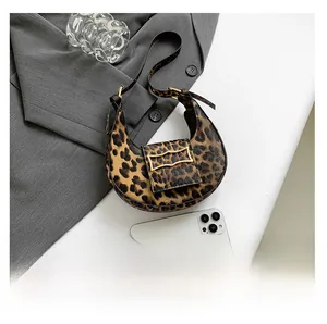 Detailed top view of leopard print crescent bag with gold buckle and size comparison