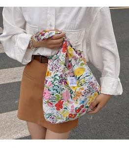 Gros plan du sac cabas en toile à fleurs avec motifs de roses colorées et étiquette tissée