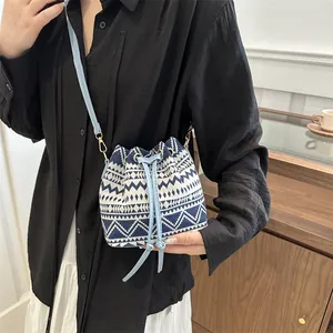 Close-up of geometric ethnic pattern bucket bag with leather drawstring and metal buckle
