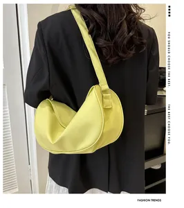 Lime green crescent shoulder bag with pleated details shown on model with black blazer