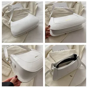 Detail view of white leather crossbody bag showing internal compartments and golden hardware